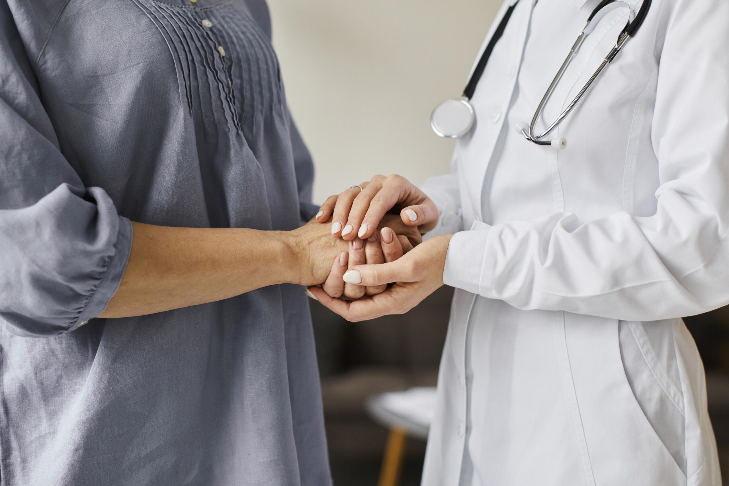 Doctor holding patients hands